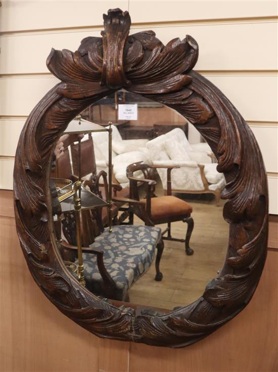 An early 19th century oval carved wall mirror